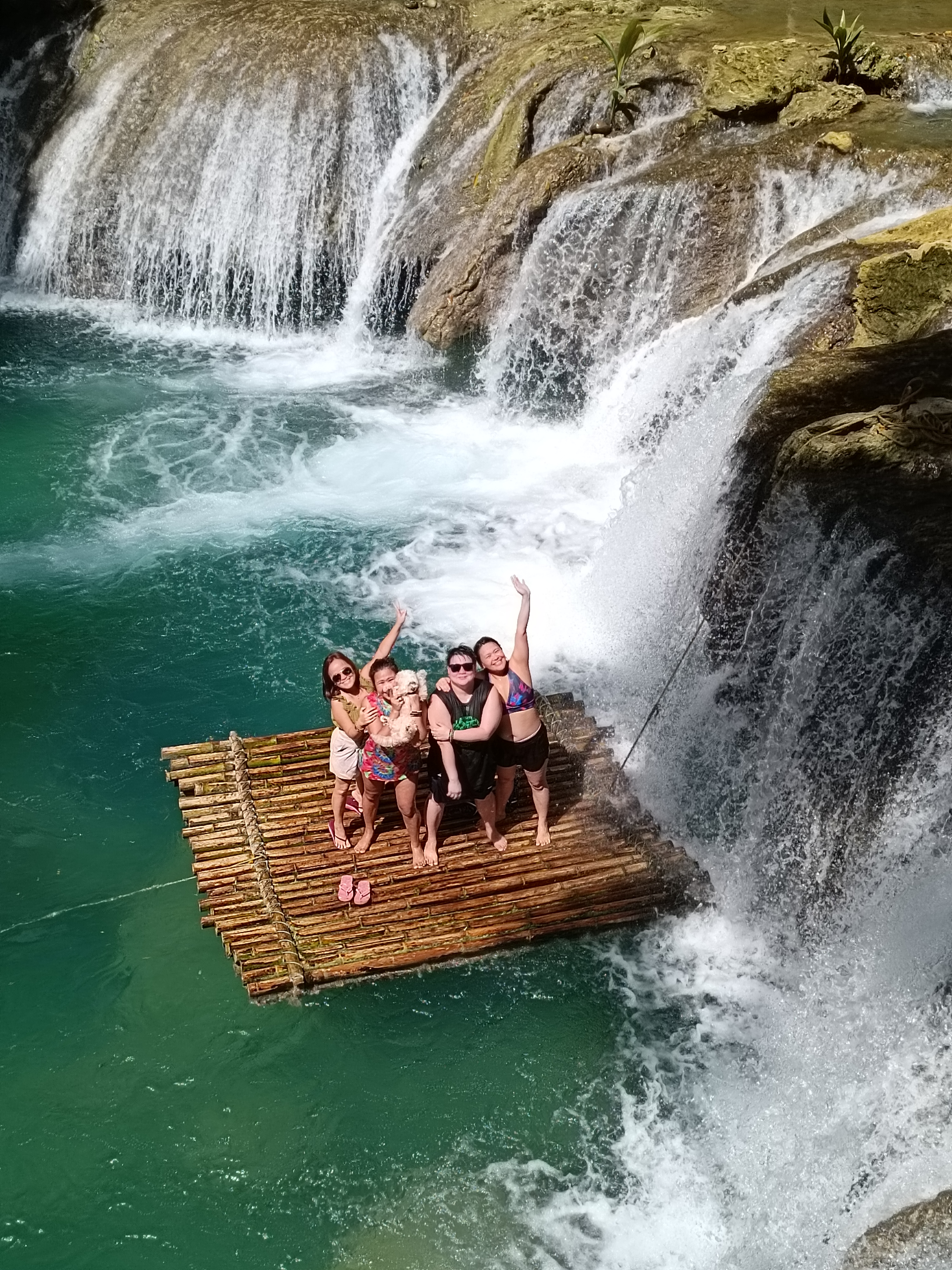 Group of friends on a bamboo raft at the waterfall
